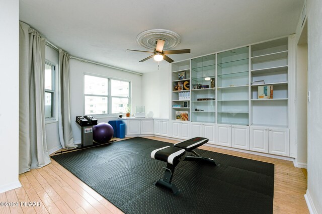 workout area featuring ceiling fan and light hardwood / wood-style floors