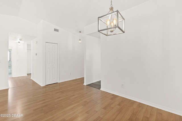 1197 Stillwood Ct, Port Orange, FL 32129 - unfurnished dining area featuring a chandelier, vaulted ceiling, light wood-style flooring, and visible vents
