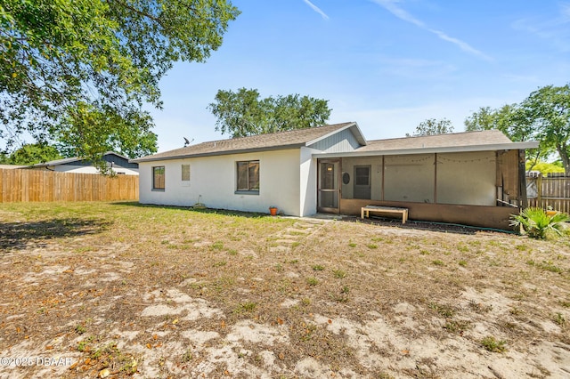 1197 Stillwood Ct, Port Orange, FL 32129 - rear view of property featuring fence, a sunroom, a yard, and stucco siding