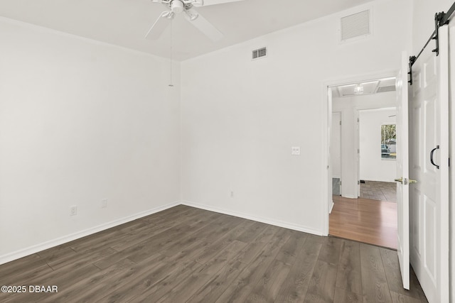 1197 Stillwood Ct, Port Orange, FL 32129 - empty room with a ceiling fan, visible vents, dark wood-style floors, and a barn door