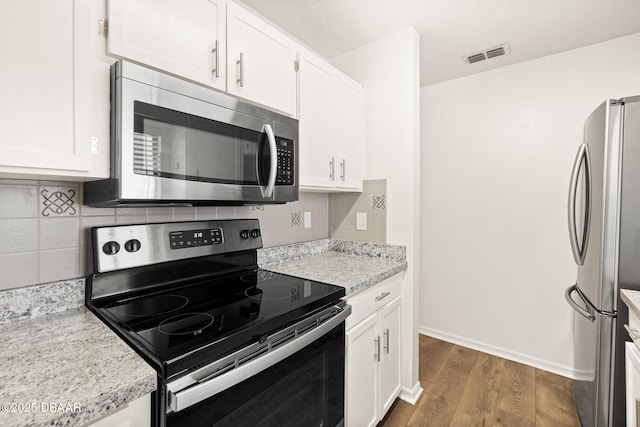 1197 Stillwood Ct, Port Orange, FL 32129 - kitchen featuring wood finished floors, decorative backsplash, stainless steel appliances, white cabinets, and visible vents