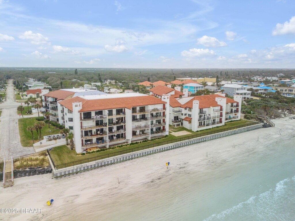 birds eye view of property featuring a water view and a beach view