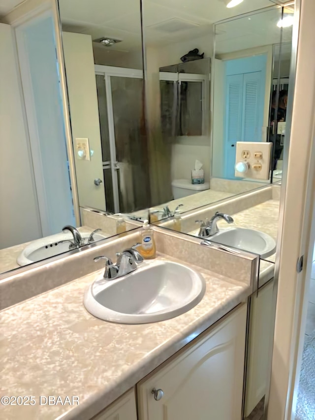 bathroom with walk in shower, vanity, and toilet