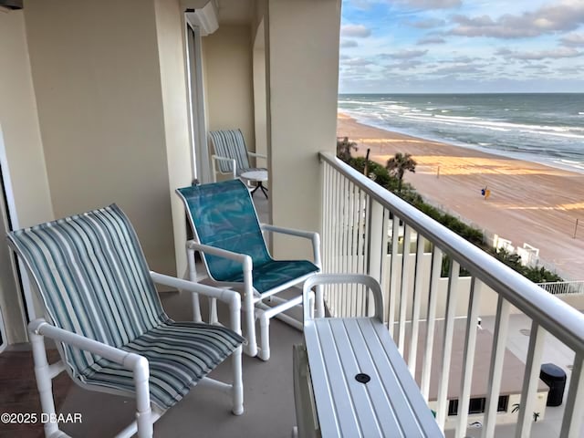 balcony featuring a beach view and a water view