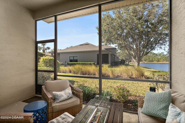 sunroom / solarium featuring a water view