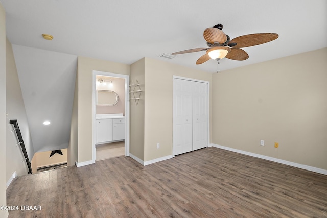 unfurnished bedroom with a closet, hardwood / wood-style flooring, ensuite bath, and ceiling fan