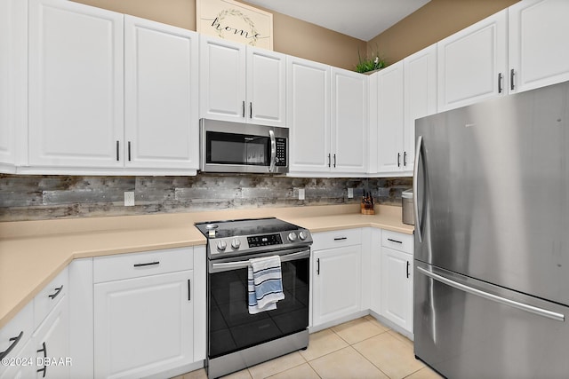 kitchen featuring backsplash, white cabinetry, light tile patterned floors, and appliances with stainless steel finishes