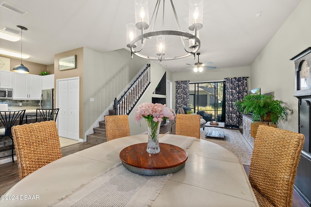 dining room featuring ceiling fan with notable chandelier and light wood-type flooring