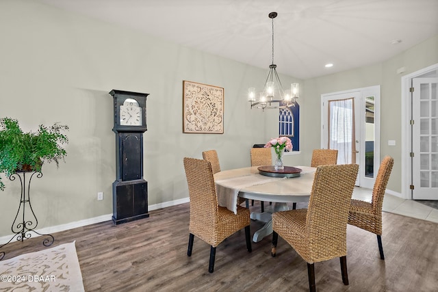 dining space featuring wood-type flooring and an inviting chandelier