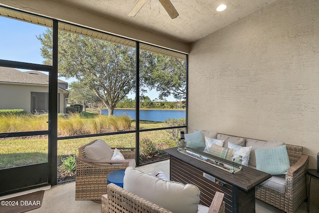 sunroom / solarium with ceiling fan and a water view