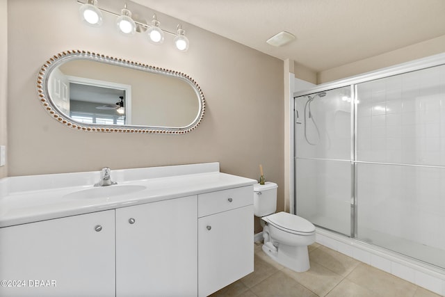 bathroom featuring walk in shower, vanity, ceiling fan, tile patterned flooring, and toilet