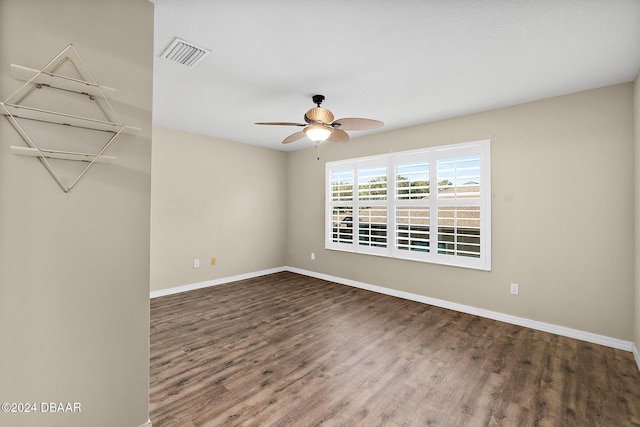 spare room featuring ceiling fan and dark wood-type flooring