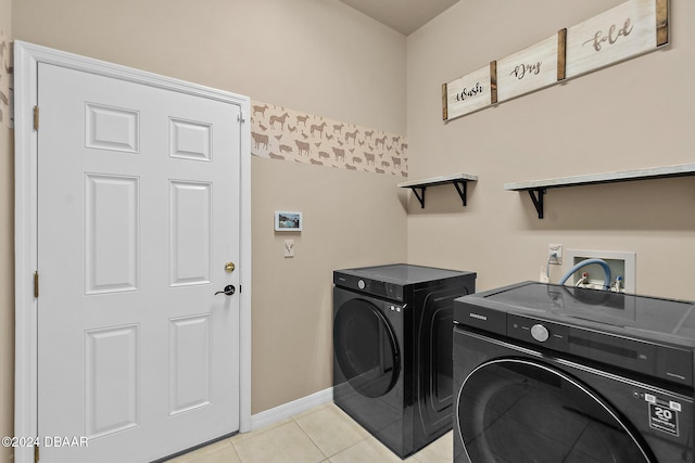 clothes washing area with washer and clothes dryer and light tile patterned floors