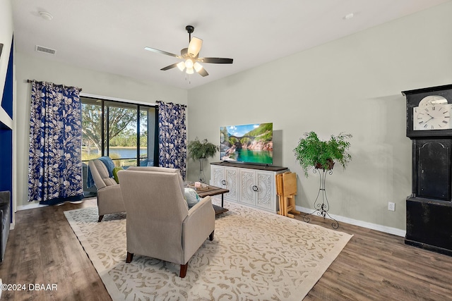 living room with dark hardwood / wood-style floors and ceiling fan