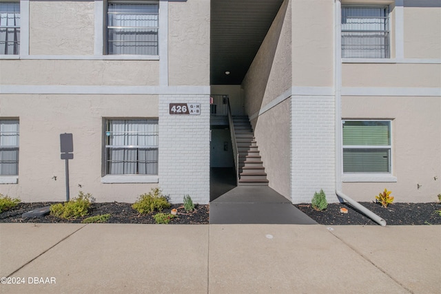 entrance to property with stucco siding and brick siding