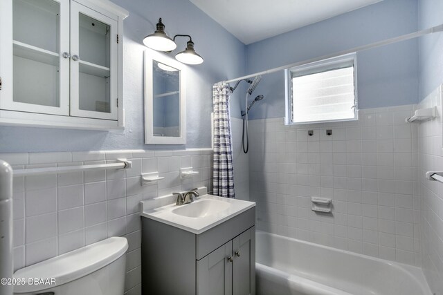 39 Seaview Dr, Ormond Beach, FL 32176 - full bath with vanity, a wainscoted wall, toilet, shower / bath combo with shower curtain, and tile walls