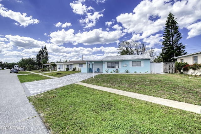 39 Seaview Dr, Ormond Beach, FL 32176 - view of front of home featuring driveway, a front yard, fence, and metal roof