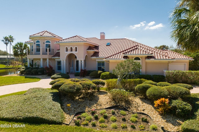 mediterranean / spanish house featuring a front yard and a balcony