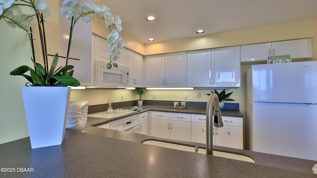 kitchen featuring white appliances, sink, and white cabinets