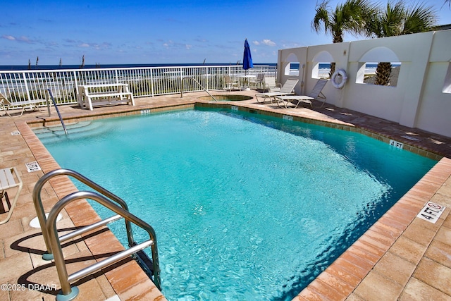 view of swimming pool with a water view and a patio area