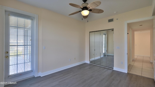 unfurnished bedroom featuring ceiling fan, dark hardwood / wood-style flooring, and a closet