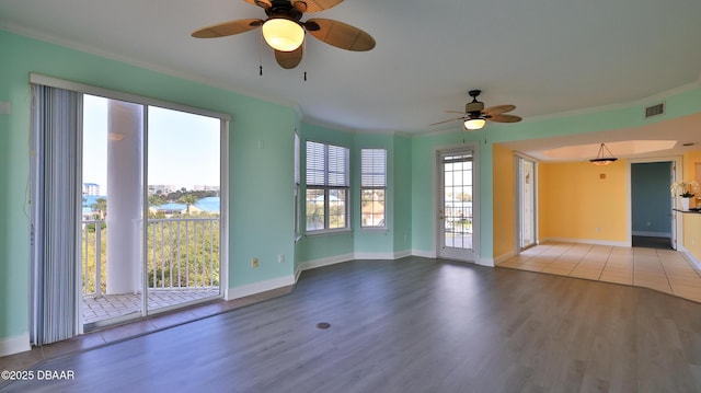 empty room featuring hardwood / wood-style flooring, ornamental molding, and ceiling fan