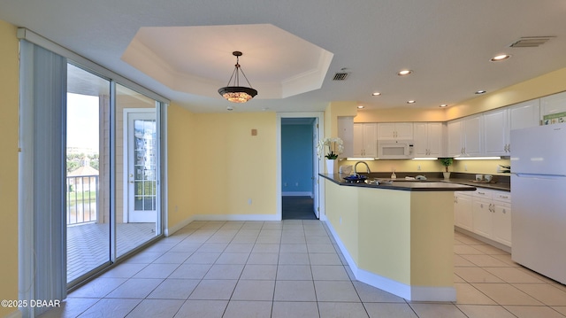 kitchen featuring decorative light fixtures, white cabinetry, light tile patterned floors, a raised ceiling, and white appliances