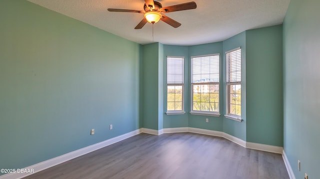 spare room featuring wood-type flooring, ceiling fan, and a textured ceiling