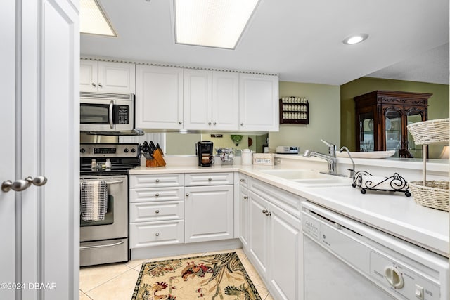 kitchen with appliances with stainless steel finishes, white cabinets, and light tile patterned floors