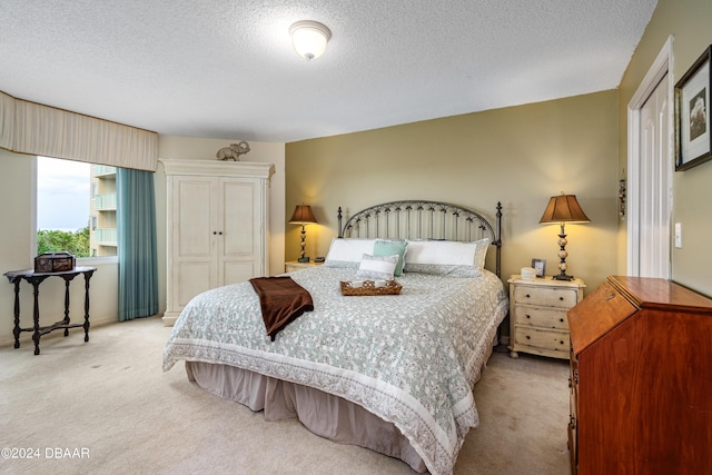 bedroom with a textured ceiling, a closet, and light carpet