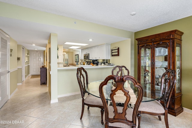 tiled dining room featuring a textured ceiling