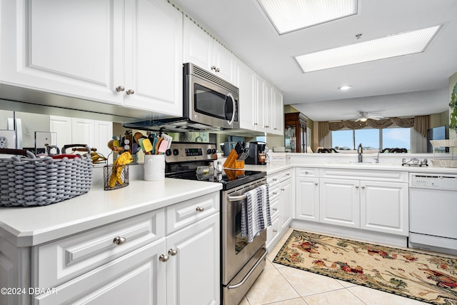 kitchen featuring sink, kitchen peninsula, appliances with stainless steel finishes, and white cabinetry