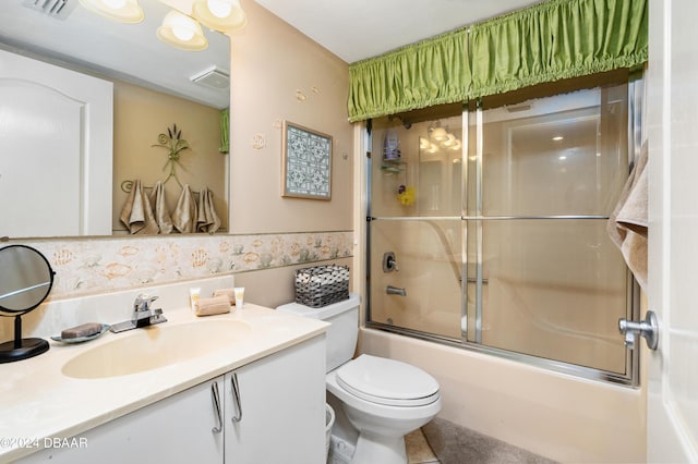 full bathroom featuring shower / bath combination with glass door, toilet, and vanity