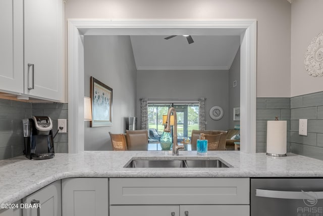 kitchen featuring sink, tasteful backsplash, light stone countertops, white cabinets, and dishwasher