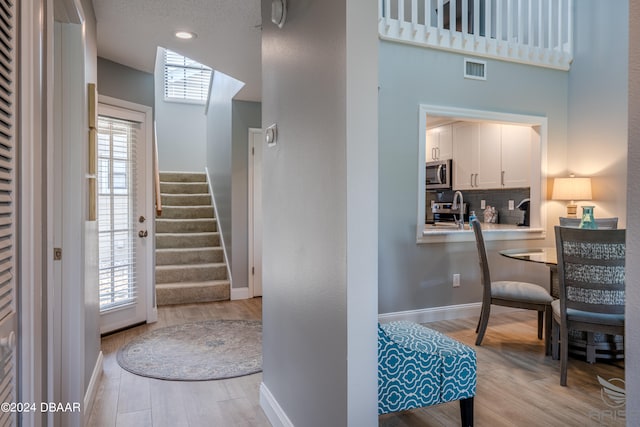 interior space with a textured ceiling and light hardwood / wood-style floors