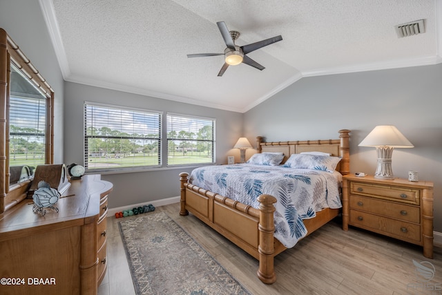 bedroom with light hardwood / wood-style flooring, lofted ceiling, ceiling fan, and crown molding