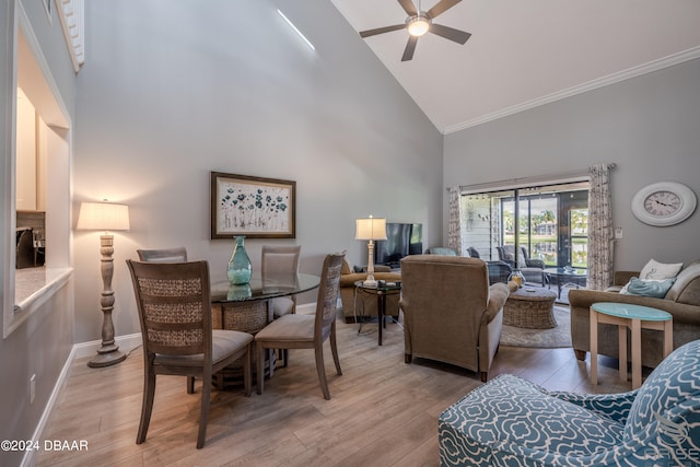 living room with ceiling fan, crown molding, light wood-type flooring, and high vaulted ceiling