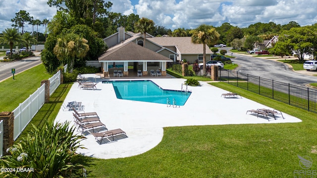 view of swimming pool featuring an outdoor fire pit, a lawn, and a patio