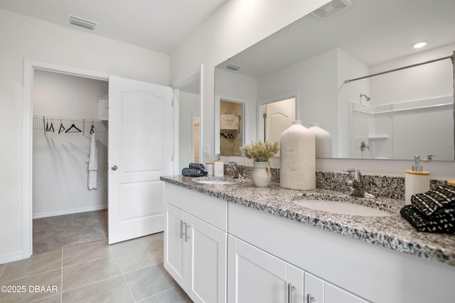 bathroom with vanity, tile patterned flooring, and a shower