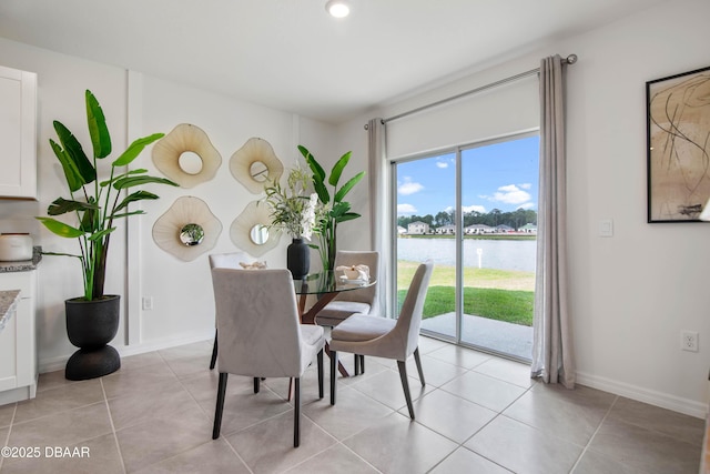 dining room featuring a water view and light tile patterned flooring