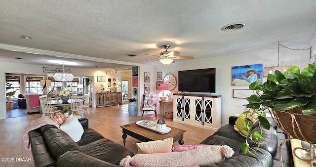 living room with crown molding, a textured ceiling, ceiling fan, and wood finished floors
