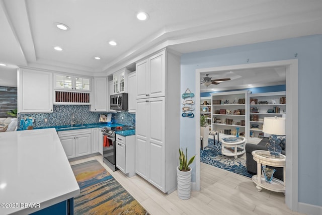 1942 N Daytona Ave, Flagler Beach, FL 32136 - kitchen featuring appliances with stainless steel finishes, a sink, tasteful backsplash, white cabinets, and glass insert cabinets