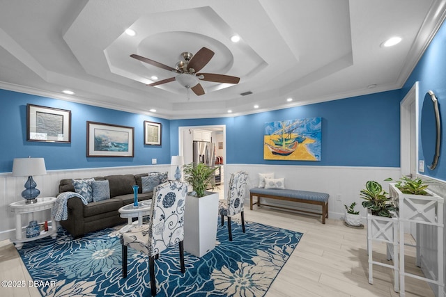 1942 N Daytona Ave, Flagler Beach, FL 32136 - living room featuring a raised ceiling, a ceiling fan, crown molding, a wainscoted wall, and recessed lighting