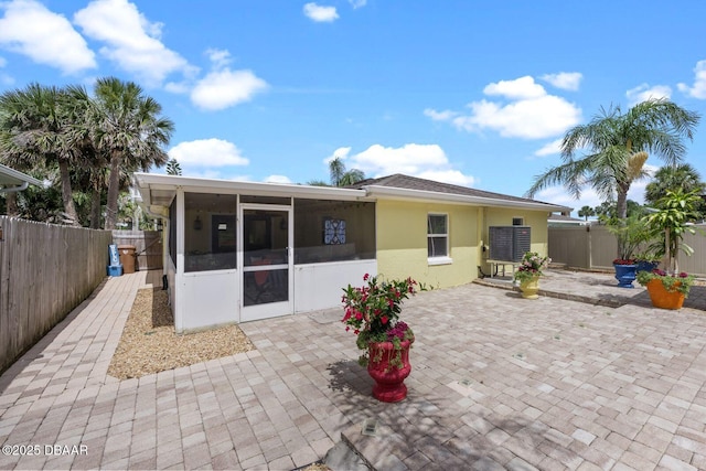 1942 N Daytona Ave, Flagler Beach, FL 32136 - back of property featuring a sunroom, a fenced backyard, stucco siding, and a patio area