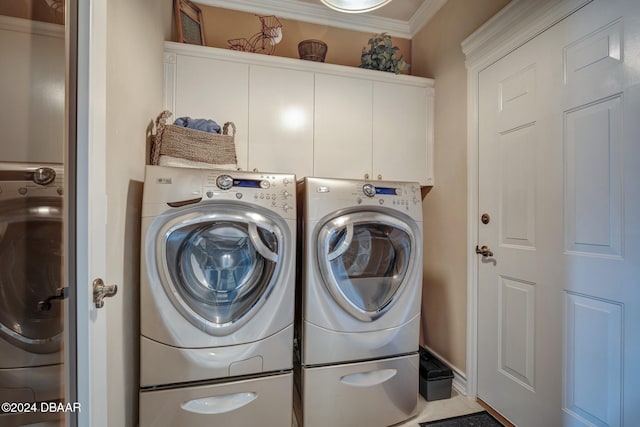 clothes washing area with washer and dryer, cabinets, and ornamental molding