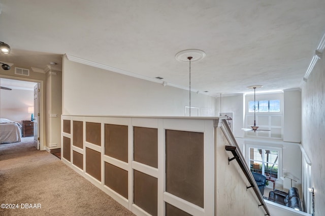 hallway featuring carpet flooring, plenty of natural light, and crown molding