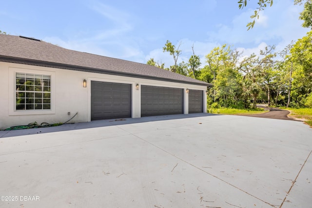 garage featuring concrete driveway