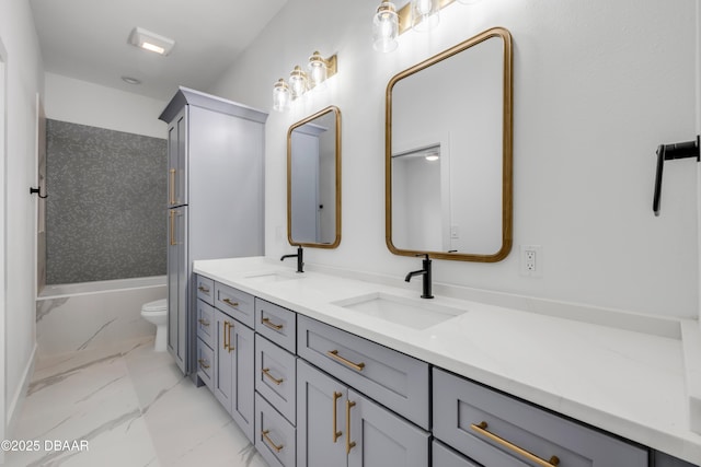 full bathroom with marble finish floor, double vanity, toilet, and a sink
