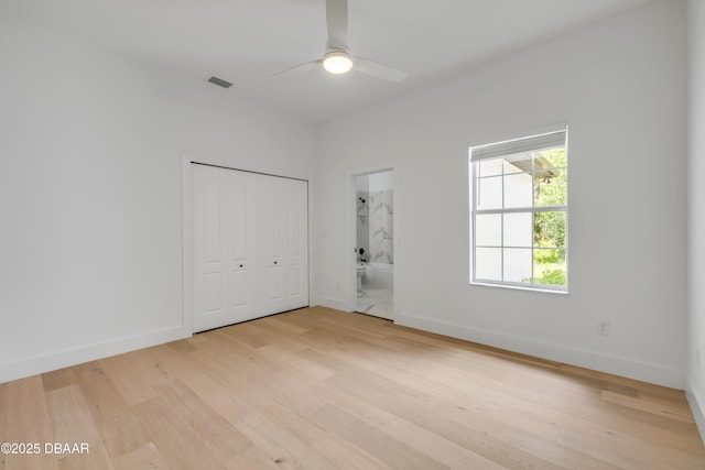 unfurnished bedroom featuring visible vents, connected bathroom, light wood-style floors, a closet, and baseboards