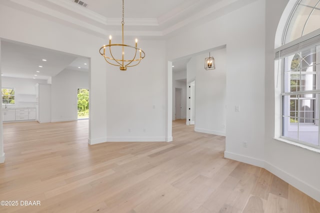 unfurnished dining area with baseboards, a healthy amount of sunlight, a chandelier, and light wood-style floors